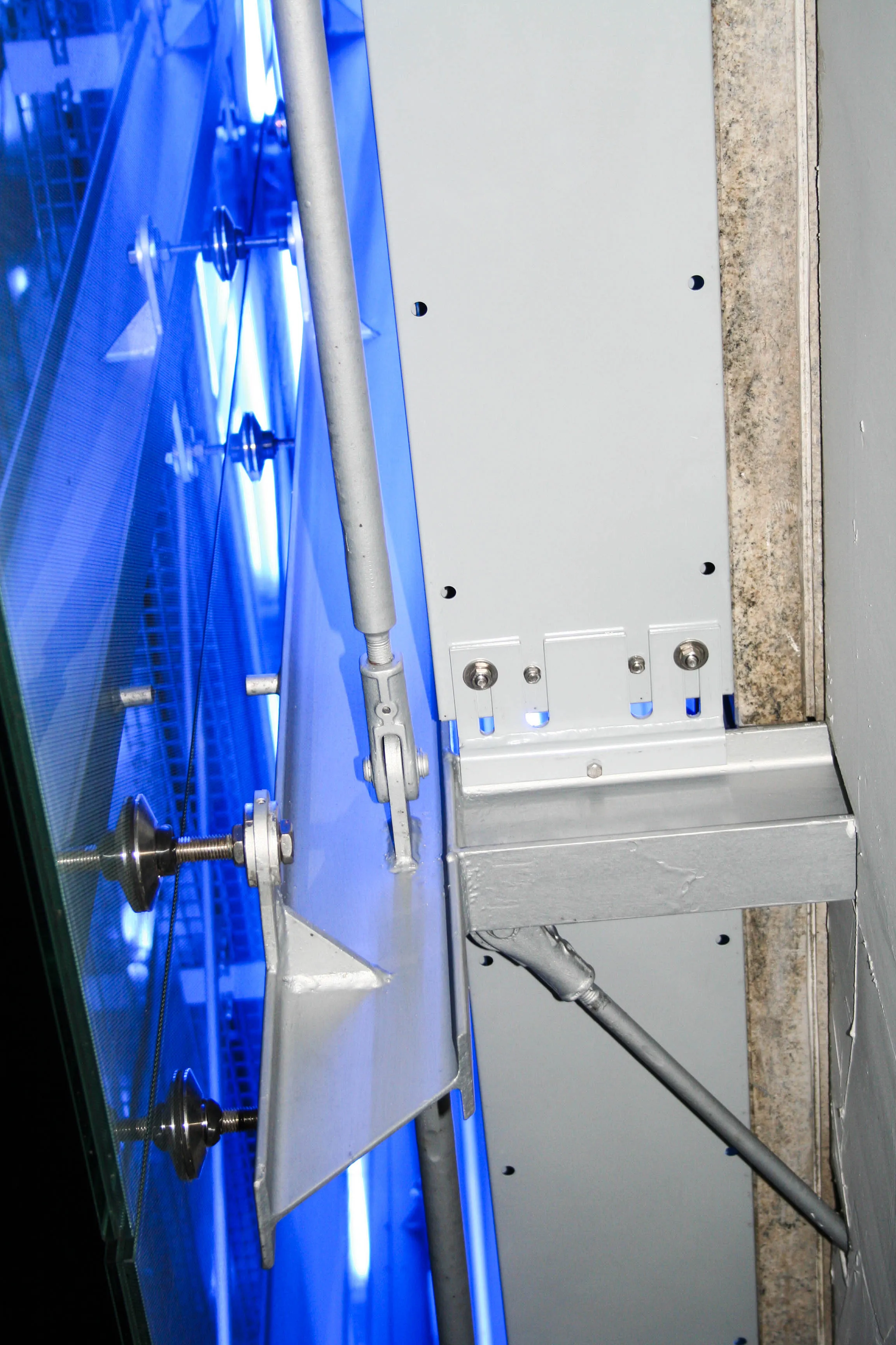 Detailaufnahme der Punkthalter und Stahlunterkonstruktion mit blauer LED-Hinterleuchtung