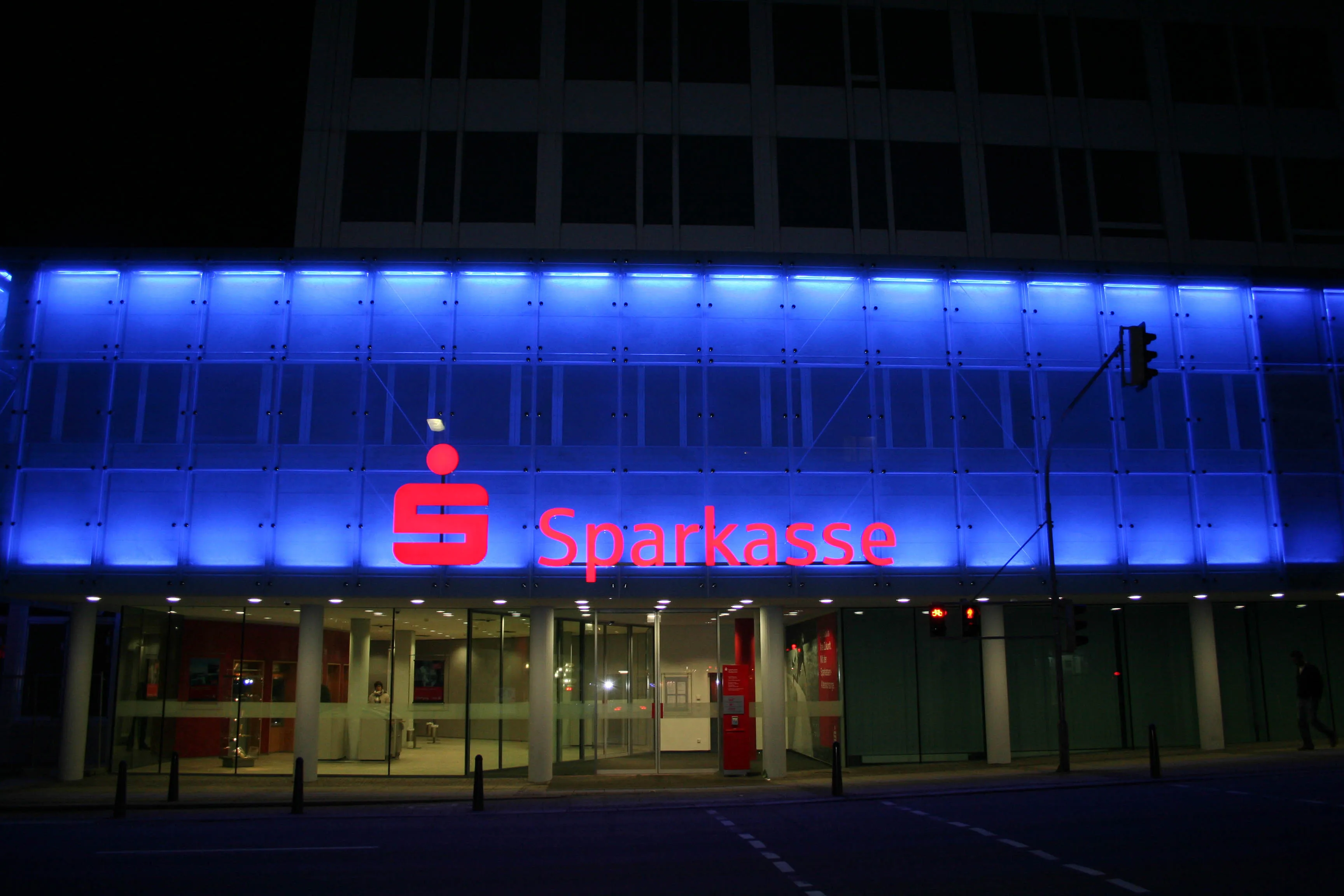 Glasfassade bei Nacht in Sparkassen-Blau hinterleuchtet