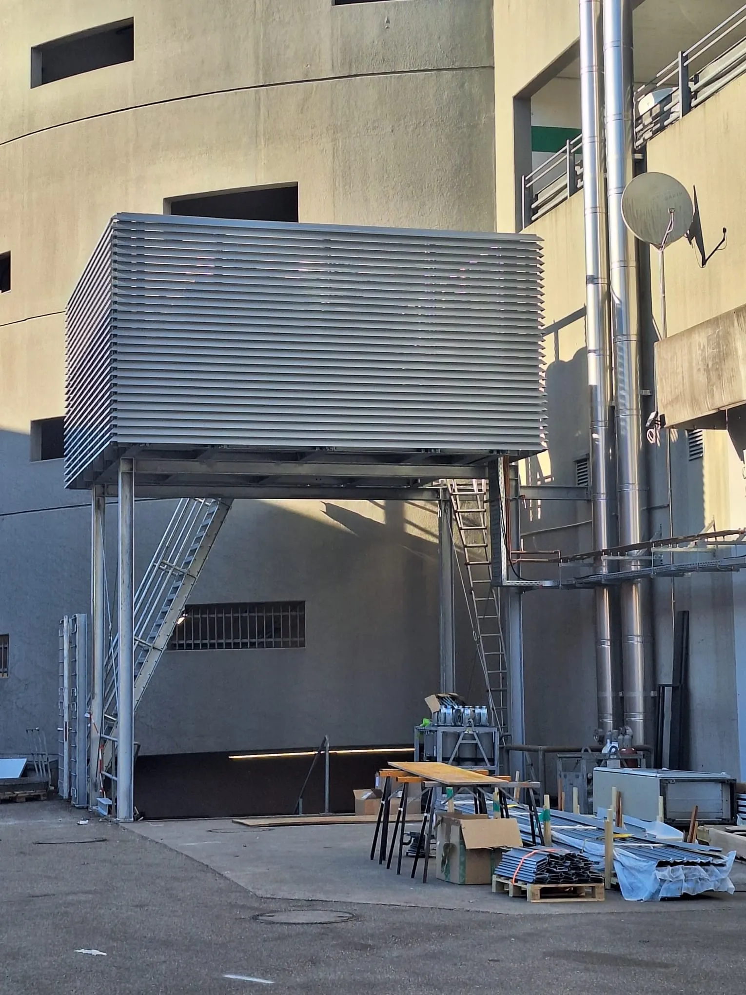Aufgeständerte Lärmschutz-Einhausung aus Stahl mit umlaufenden Aluminium-Lamellen