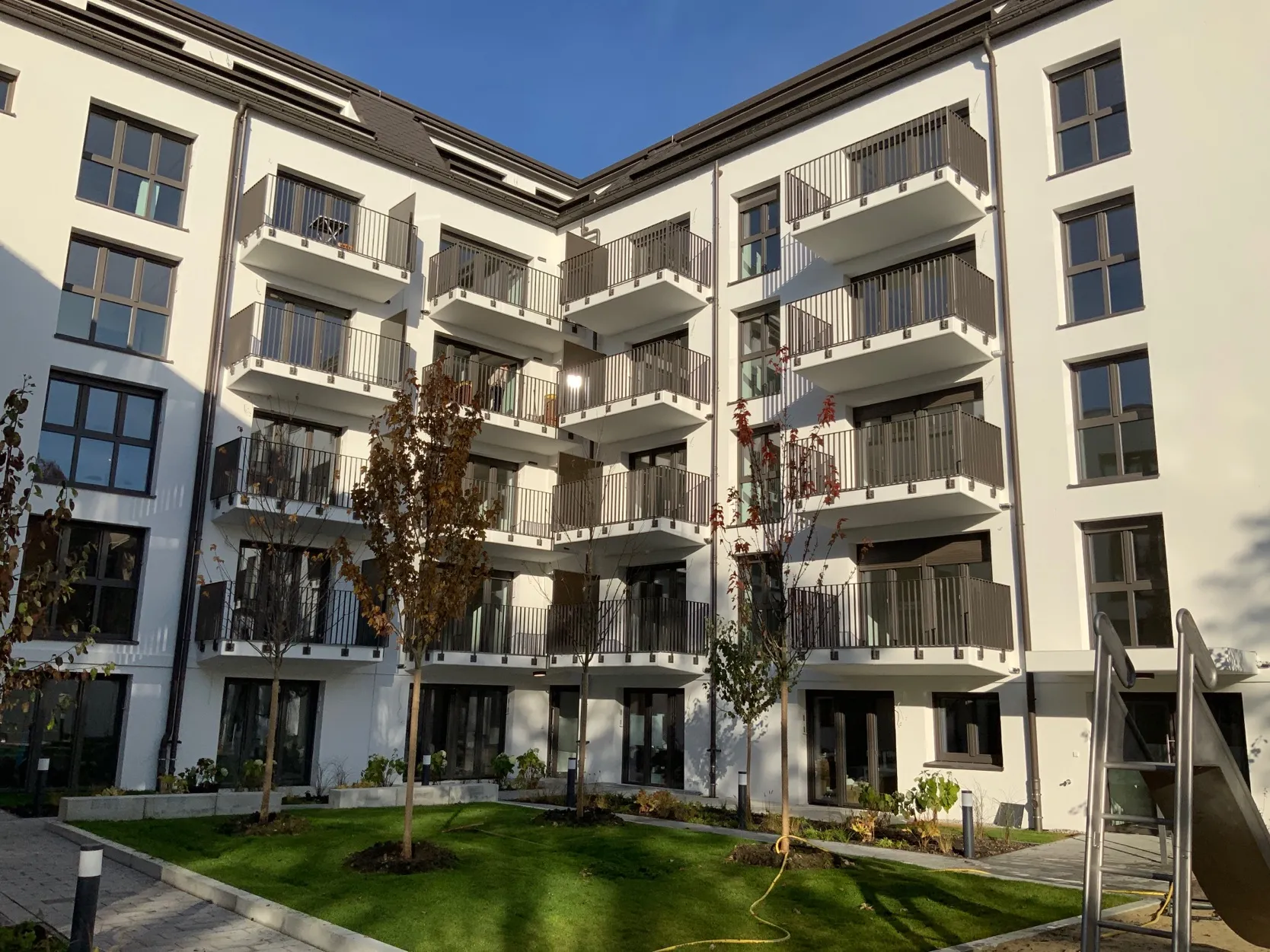 Anthrazitfarbene vorgehängte Stahlbalkone im Innenhof eines Wohnquartiers in München