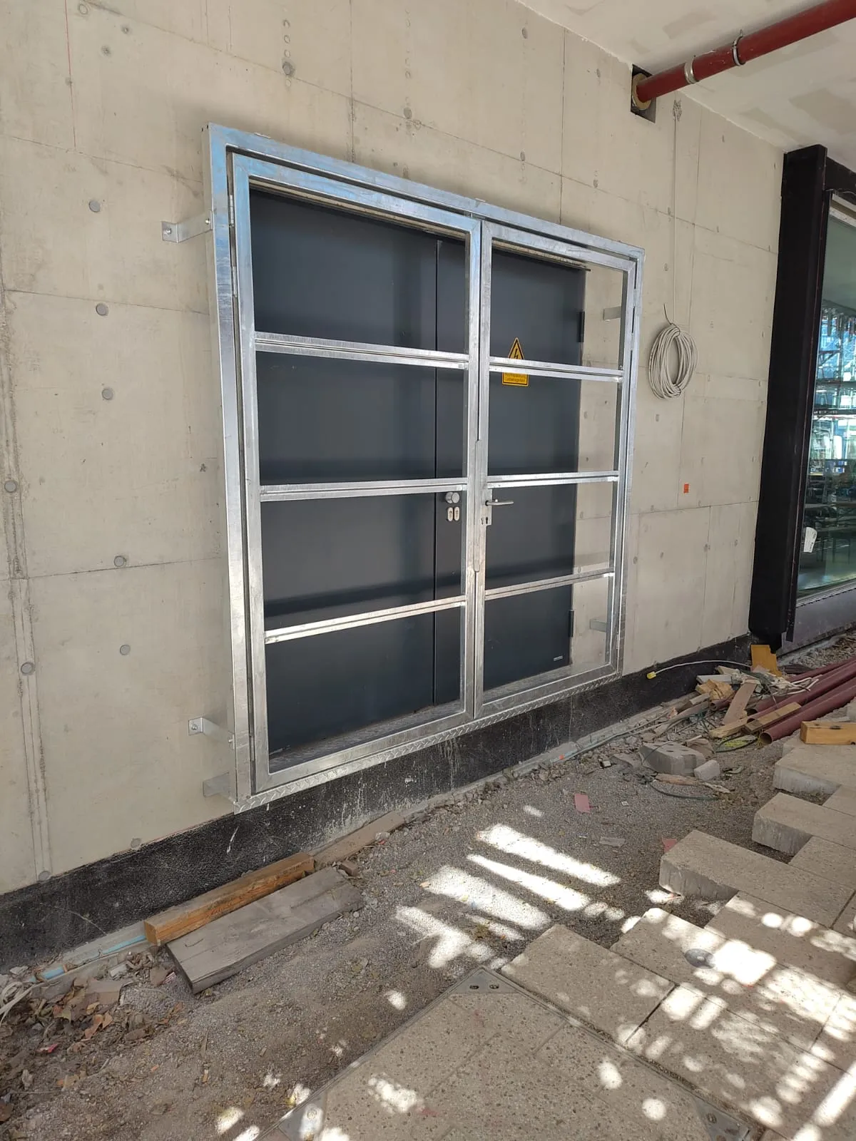 Feuerverzinkter Stahlrahmen als Unterkonstruktion einer Tapetentür vor der Betonwand